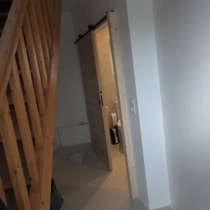 Porte à galandage couleur bois clair, pour faciliter l'accès à la salle de bain