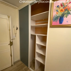 Placard sur mesure réalisé dans l'entrée avec étagères et portes sur rails