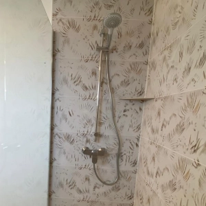 Faïence blanche avec motifs de feuilles dorées, colonne de douche moderne et durable
