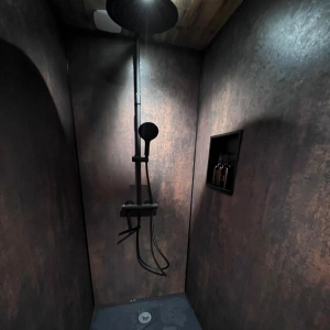 Douche avec panneaux muraux design foncés, receveur noir, niche murale noire pour ranger les produits, spots encastrés