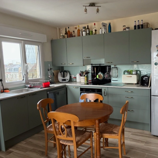 Cuisine aménagée et équipée sur mesure, façades vert d'eau, plan de travail clair