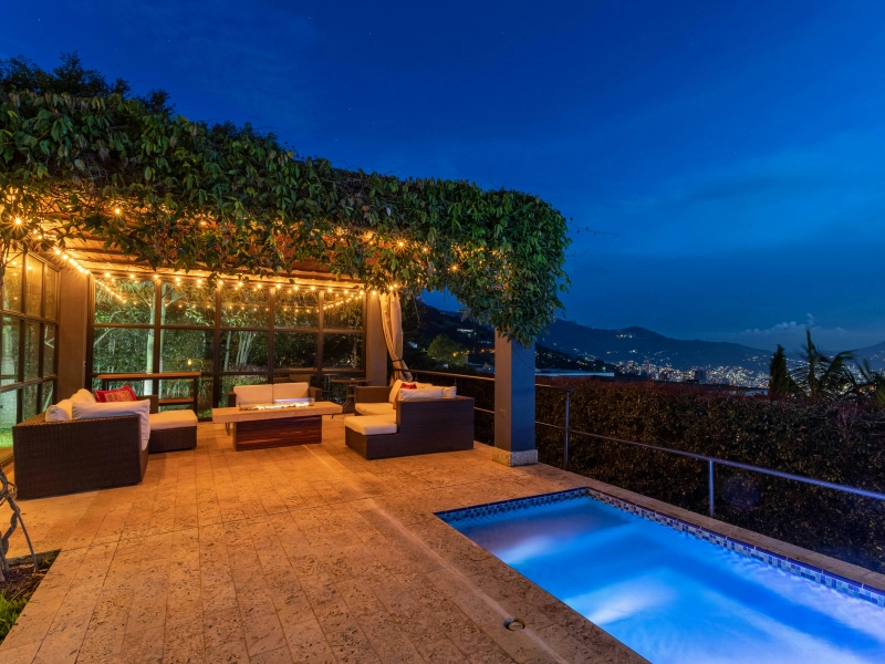Extérieur avec piscine, terrasse et salon de jardin sous pergola éclairée