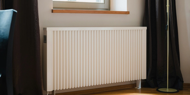 Radiateur mural blanc sous une fenêtre, illustrant nos interventions de dépannage chauffage